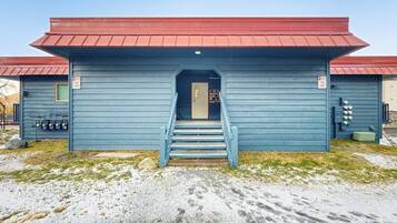 A building with a red roof, a staircase leading to a door, and a sign indicating 'Fire Lane' on the side.