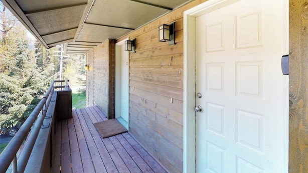 Una terraza de madera con una puerta blanca y un pequeño porche.