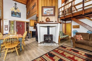 Amplia sala de estar con chimenea, muebles de madera y un techo alto.