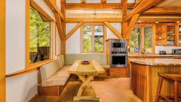 A kitchen with wooden beams, a built-in oven, and a large window.