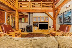 A cozy living room with a fireplace, wooden furniture, and a television.