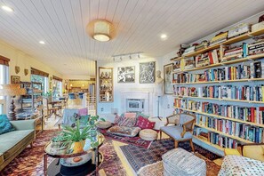 A cozy living room with a fireplace, bookshelves, and comfortable seating. - One-bedroom Loft in Anchorage's Bootlegger Cove (Anchorage)