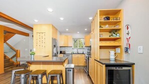 Una cocina moderna con gabinetes de madera, un refrigerador de acero inoxidable y un lavavajillas empotrado.