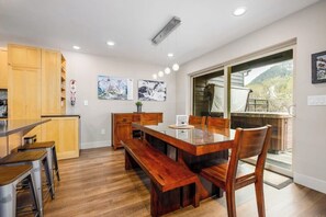 Una cocina moderna con armarios de madera, una mesa de comedor con bancos y obras de arte en las paredes.