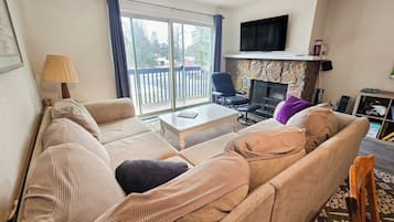 Una sala de estar con un sofá, una mesa de centro, un televisor y una chimenea.