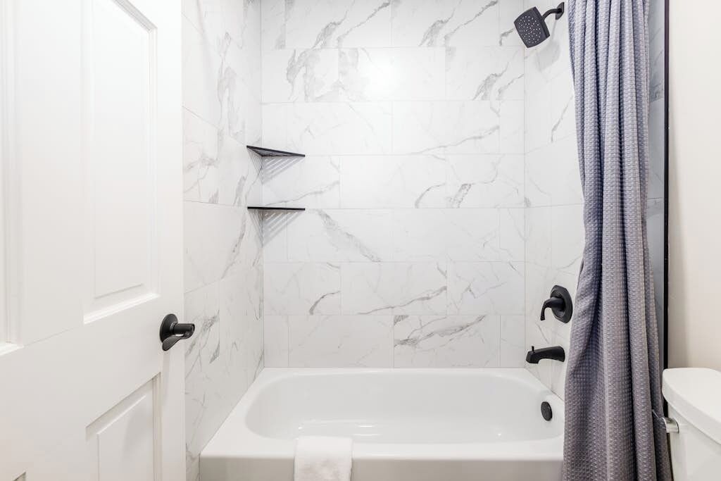 Un baño con bañera, ducha y retrete.