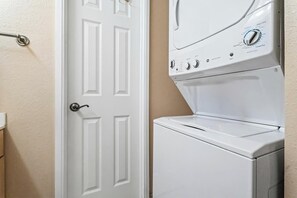 A white door with a silver handle and a white wall.