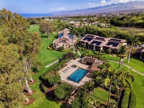 A residential property with a swimming pool, a tennis court, and a view of the ocean.