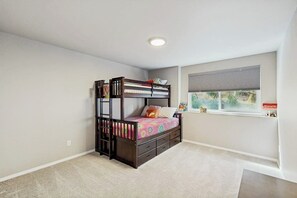 A bedroom with a bunk bed, a window with blinds, and a carpeted floor. - Cozy Mountainside Duplex Near Virgin Creek Trailhead (Girdwood)