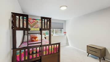 A bunk bed with a lower bunk, a small bedside table, and a window with blinds.