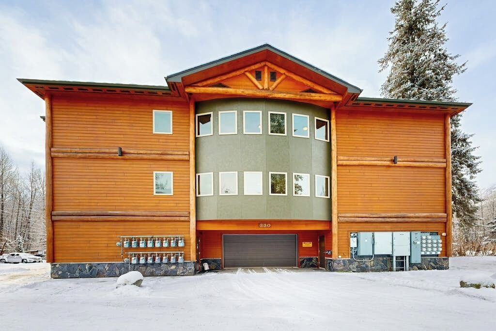Un bâtiment à deux étages, doté d’une porte de garage, d’un ensemble de bouteilles de gaz et du numéro « 380 » sur la façade.