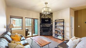 A living room with a fireplace, a sofa, a coffee table, and a bookshelf.