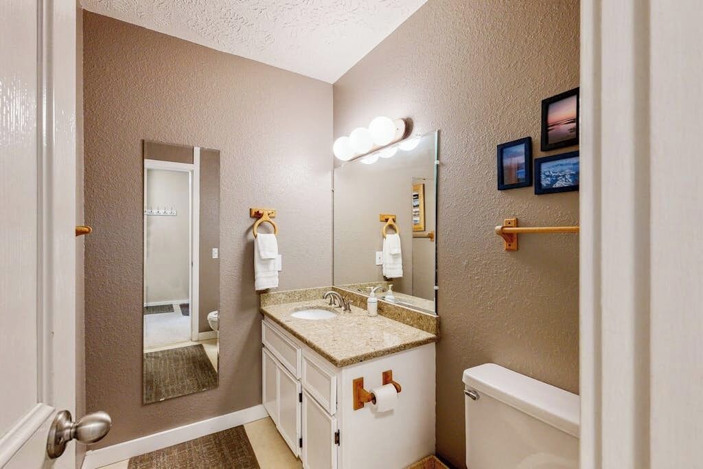 Ein Badezimmer mit Waschbecken, Spiegel und Toilette.