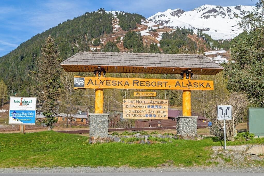 A sign for Alyeska Resort, Alaska, with directions to the hotel, ski resort, day lodge, and parking.