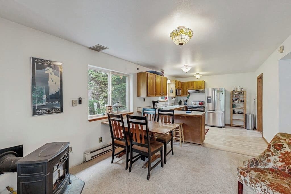 A compact living space with a dining area, kitchenette, and a fireplace.