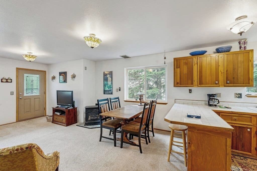 A dining area with a wooden table and chairs, a television, and a fireplace.
