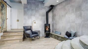 A modern interior with a fireplace, a leather chair, and a bench.