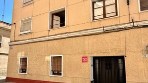 A building with a red base, multiple windows, and a door with a sign.