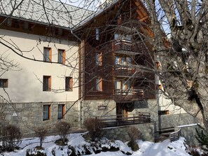 A multi-story building with a stone facade, wooden balconies, and a sign indicating 'Galibier 1'. - Apartment with parking - 6 guests (Valloire)