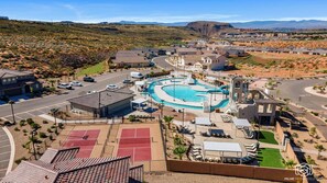 Área residencial com piscina, quadras de tênis e paisagem desértica ao fundo.