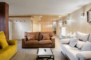A living room with two sofas, a coffee table, and a yellow armchair.