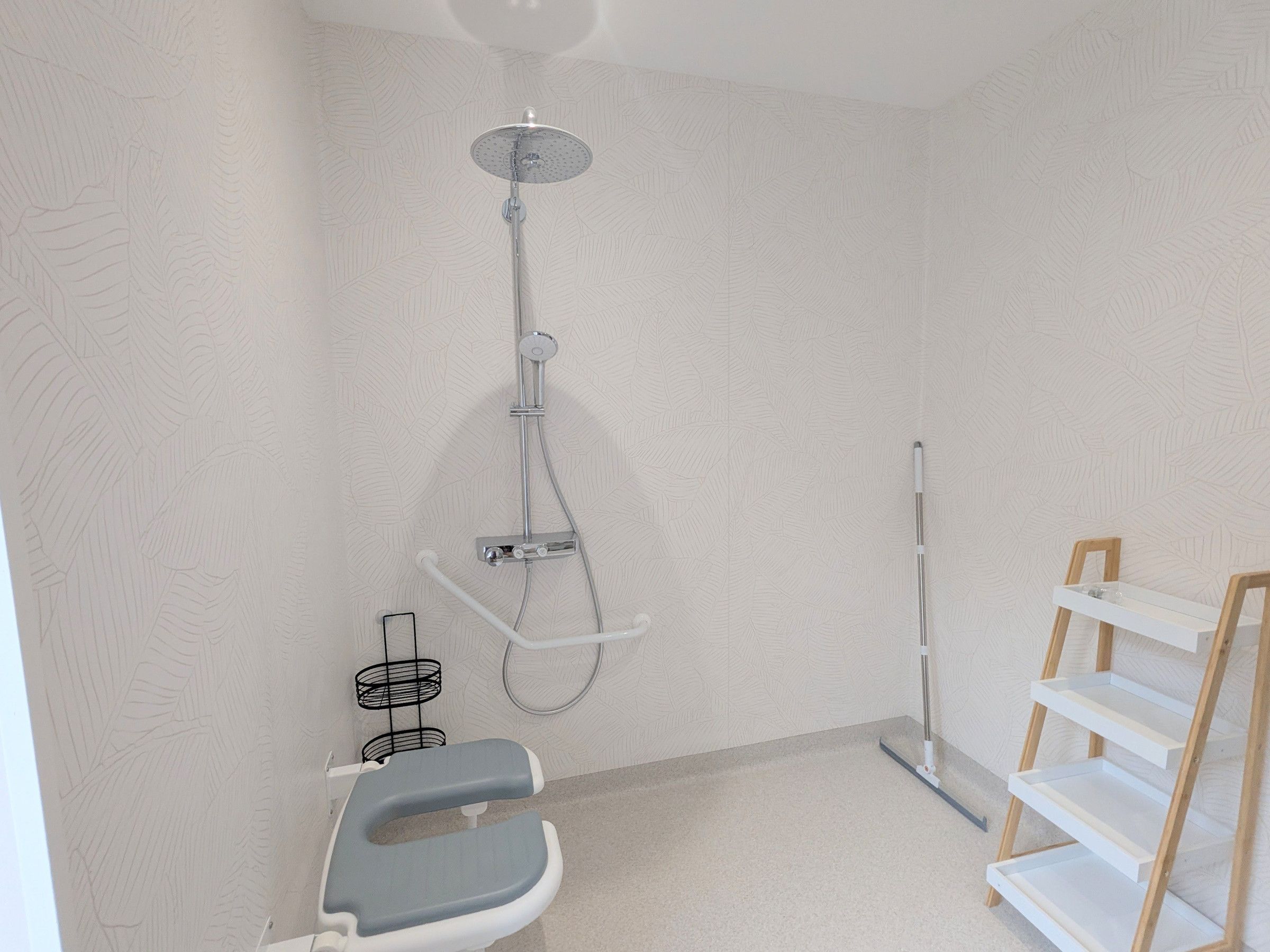 Een badkamer met een douche, toilet en een opbergmeubel.