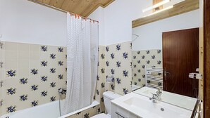 A bathroom with a bathtub, toilet, and sink. - Studio at ski slopes, Mont Blanc view (Combloux)