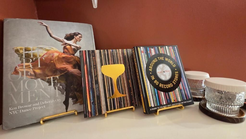 A book titled 'EIT OF LOVE' by Ken Browar and Deborah Ory, a vinyl record titled 'AROUND THE WORLD,' and a decorative item with a yellow shape.