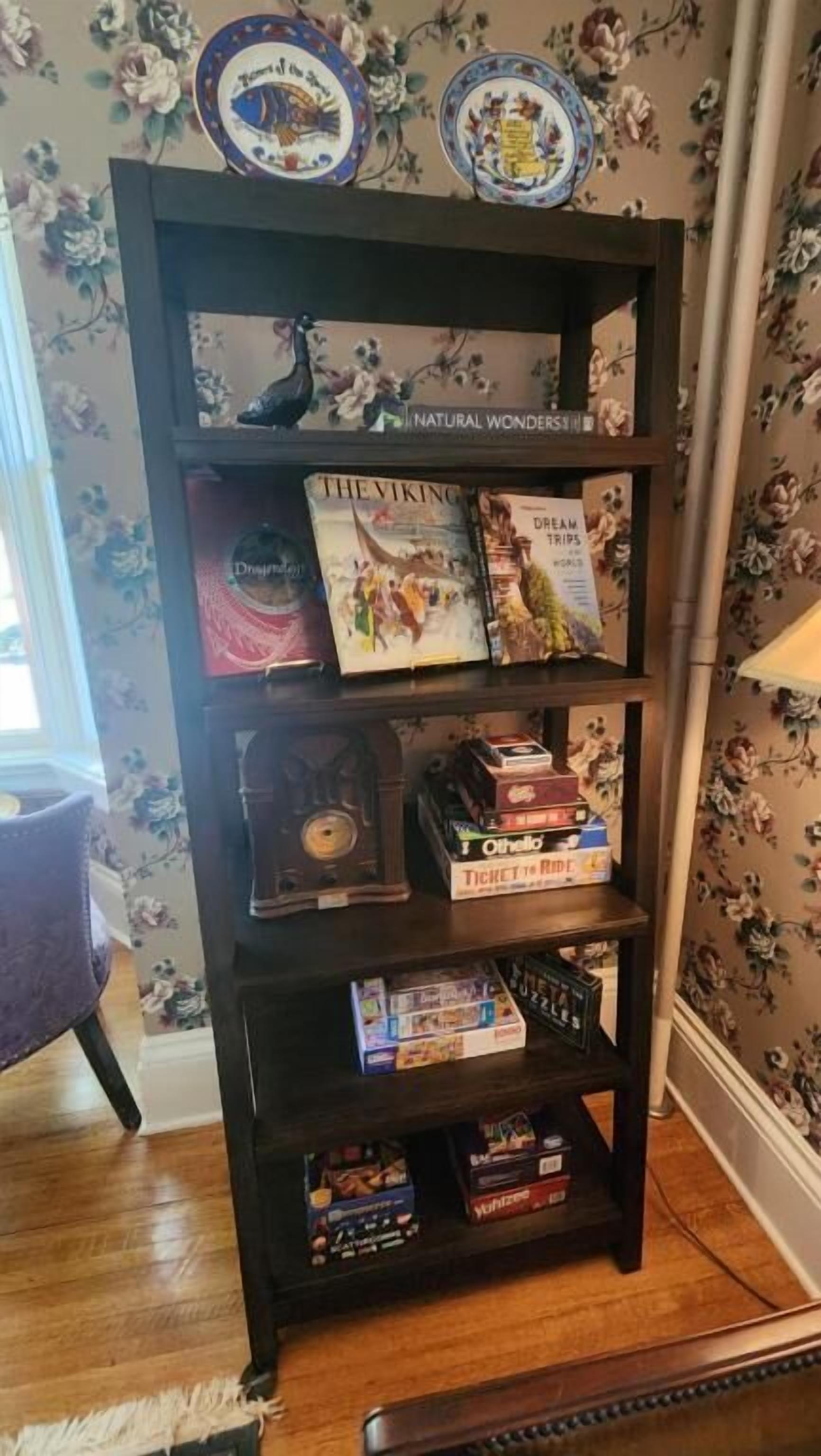 A bookshelf with books and decorative plates.
