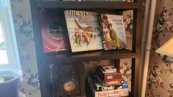 A bookshelf with books and decorative plates.