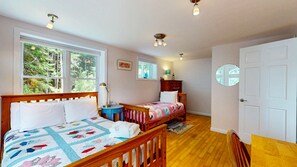 A bedroom with two beds, a window, a door, and a small table. - Waterfront Retreat with Private Dock, Kayaks & Stunning Water Views (Phippsburg)