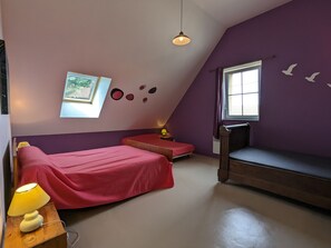 Een kamer met twee bedden, een raam, een lamp en decoratie aan de muur.