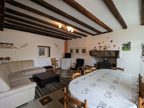 Una sala de estar acogedora con un sofá, sillas, una mesa de comedor y una chimenea.
