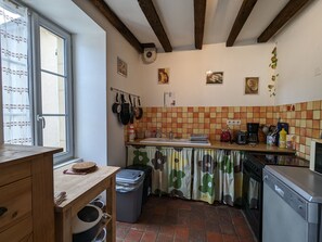 A kitchen with a tiled backsplash, a wooden table, a trash bin, and a dishwasher. - Country house in Lourouer-Saint-Laurent (Lourouer-Saint-Laurent)
