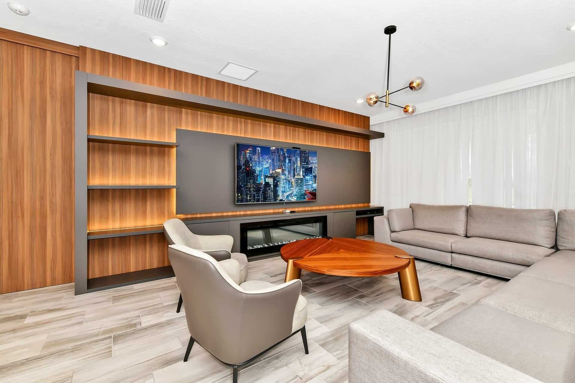 Ein modernes Wohnzimmer mit Flachbildfernseher, einer Couch, einem Couchtisch und einem Kamin.