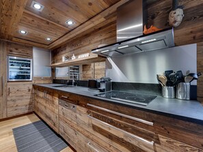 Eine moderne Küche mit Holzschränken, einer Edelstahl-Dunstabzugshaube und einem eingebauten Backofen.