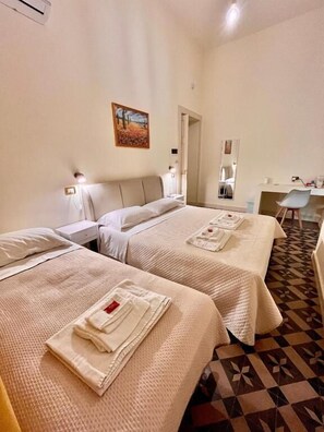 Una habitación de hotel con dos camas, un escritorio y una silla.
