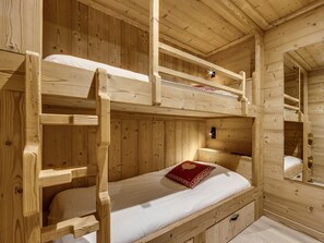A wooden cabin with bunk beds, a small mirror, and a red pillow. - Ski-in apartment - 4 guests (Val-d'Isère)