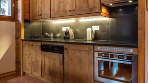 Uma cozinha moderna com armários de madeira, eletrodomésticos de aço inoxidável e forno embutido.
