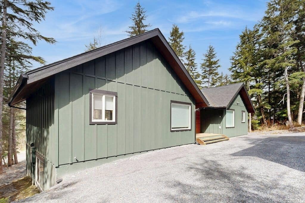A single-story building with a sloped roof, a front porch, and a gravel driveway.