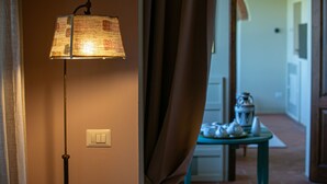 Ein Zimmer mit Stehlampe, Lichtschalter und Tisch mit Laterne.