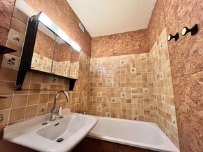 A bathroom with a sink, mirror, and bathtub. - Functional apartment, bright view - 4 guests (La Plagne)