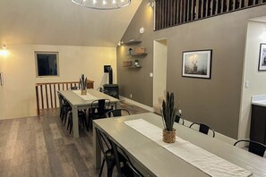 Un espace repas avec une longue table, des chaises et une plante servant de décoration centrale.