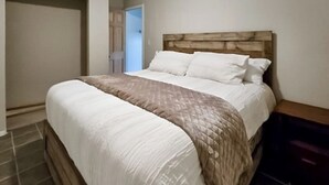 Ein Schlafzimmer mit einem Bett, einem Holz-Kopfteil und einem Nachttisch.