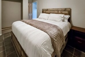 Ein Schlafzimmer mit einem Bett, einem Holz-Kopfteil und einem Nachttisch.