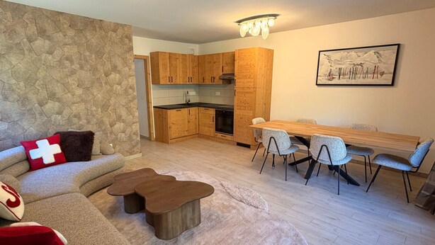 Una sala de estar moderna con un sofá, una mesa de centro y un comedor con sillas y una mesa.