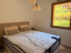 Ein Bett mit einer weißen Matratze, zwei Kissen und einem Kopfteil.