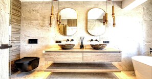 Un bagno moderno con due lavabi, uno specchio grande e un water nero.