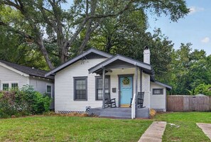A single-story house with a porch, a chimney, and a blue door. - The Dellwood Cottage - Near Local Shops & Eats (Jacksonville)
