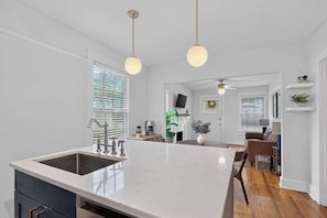 A kitchen with a large island, a built-in sink, and pendant lighting. - The Dellwood Cottage - Near Local Shops & Eats (Jacksonville)